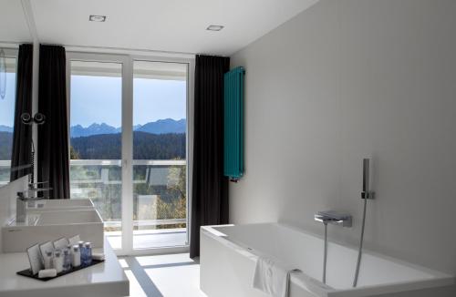 a bathroom with a tub and a large window at Hotel HARNAŚ dla dorosłych z widokiem na Tatry in Bukowina Tatrzańska