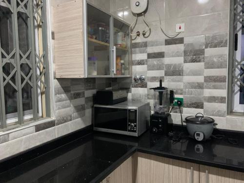 een keuken met een zwart aanrecht met een magnetron bij Family & Friends Apartments in Miocho