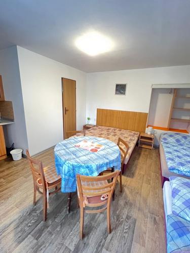 a room with two beds and a table and chairs at Ubytování Sýkora Apartments in Veľký Meder