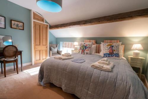 a bedroom with a large bed with towels on it at Charming Coates Cottage in Baslow