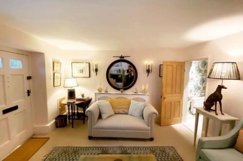 a living room with a chair and a mirror at Charming Coates Cottage in Baslow