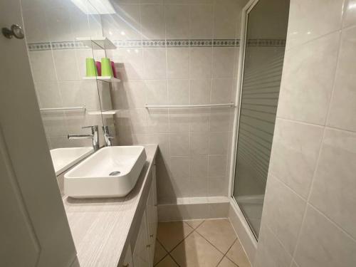 une salle de bain blanche avec un lavabo et une douche dans l'établissement AS24091- P3 Dans un secteur calme avec parking privé, au Grau-du-Roi