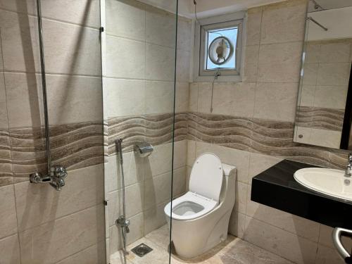 a bathroom with a toilet and a sink at Hamsun Apart Hotel Clifton in Karachi
