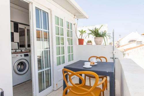 a small table and chairs on a balcony with a washing machine at Governors Row Studios in Lagos