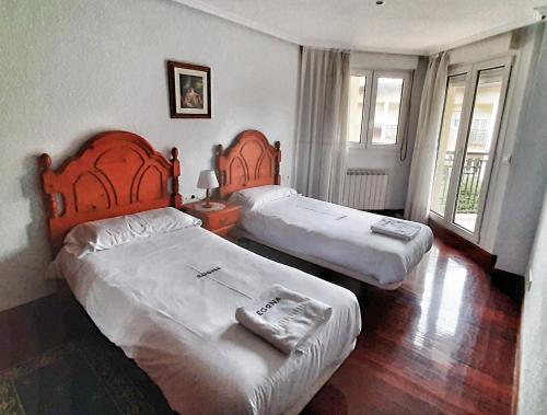 two beds in a hotel room with two beds at EGONA- H130 Villa adosada con jardín y txoko - ESS03192 in Zarautz