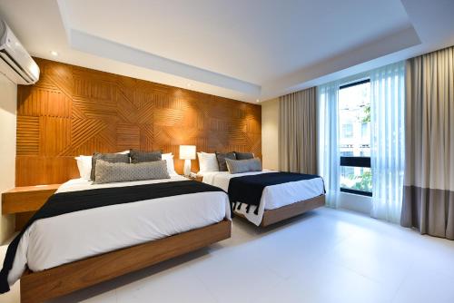1 dormitorio con 2 camas y ventana grande en The Apartments at El Nido, en El Nido