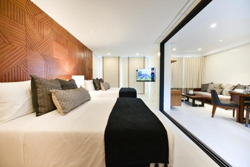 a bedroom with a large bed and a living room at The Apartments at El Nido in El Nido