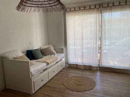 un lit dans une chambre avec une grande fenêtre dans l'établissement Centre ville - Amiral 2 / 100m de la plage, à La Grande Motte