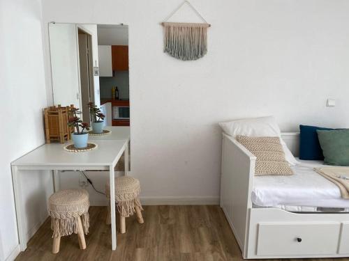 1 dormitorio con cama, escritorio y mesa en Centre ville - Amiral 2 / 100m de la plage, en La Grande-Motte