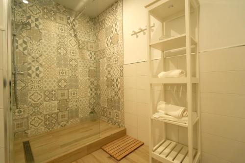 y baño con ducha, aseo y estanterías. en Apartamentos Consistorio Live, en Jerez de la Frontera