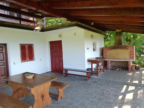 an outdoor patio with a fireplace and wooden tables at Tessina kuća in Stubicke Toplice