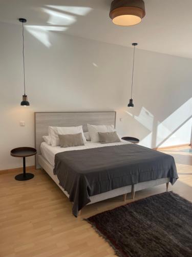 ein weißes Schlafzimmer mit einem großen Bett und einem Teppich in der Unterkunft Soho Moraleja II duplex in Alcobendas