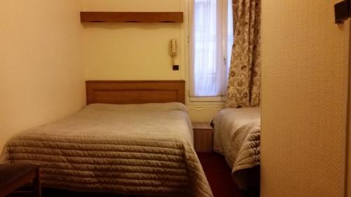 a small room with two beds and a window at Hotel Paris Bercy in Paris