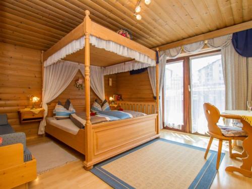 a bedroom with a canopy bed in a room at Guest house pension Neumayer in Fieberbrunn