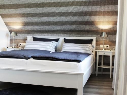 um quarto com uma cama branca e uma parede listrada em Holiday home Crimea em Pommerby