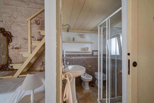 een badkamer met een wastafel, een toilet en een trap bij Casale San Giusi by Perle di Puglia in San Michele Salentino