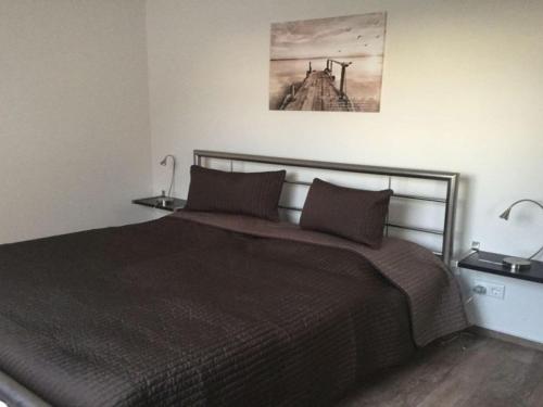 a bedroom with a bed with two lamps on it at Holiday apartment Schliekieker in Kopperby