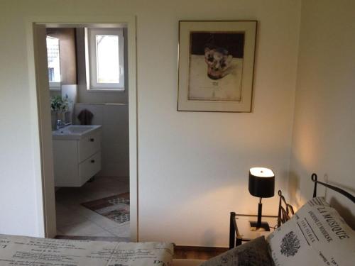 a bedroom with a bed and a bathroom with a window at Holiday apartment Schliekieker in Kopperby
