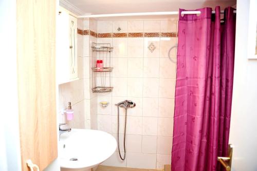 un bagno con tenda doccia rosa e lavandino di Casa center in Chania a Chania