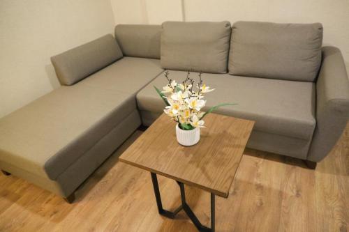 a couch with a vase of flowers on a table at UNITED HOTEL INTERNATIONAL in Yaoundé