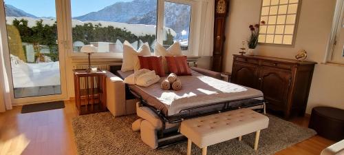 a living room with a bed with a large window at Sunny-Nest, Garden Apartment in Leukerbad