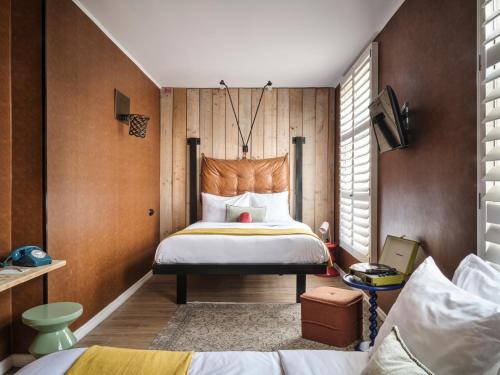 sypialnia z dużym łóżkiem i drewnianymi ścianami w obiekcie Max Brown Hotel Museum Square, part of Sircle Collection w Amsterdamie