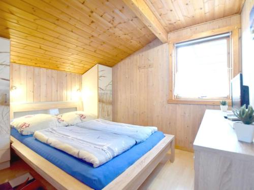 a bed in a room with a wooden ceiling at Holiday home coastal dream in Schönhagen