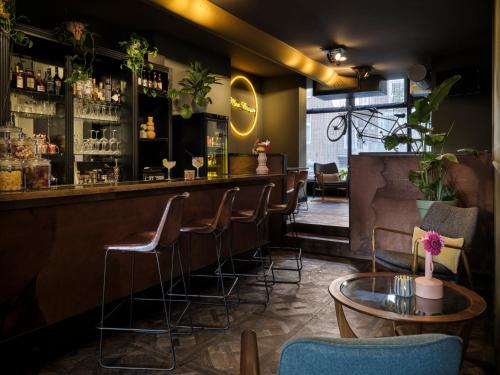 a bar with chairs and a table in a room at Max Brown Hotel Museum Square, part of Sircle Collection in Amsterdam