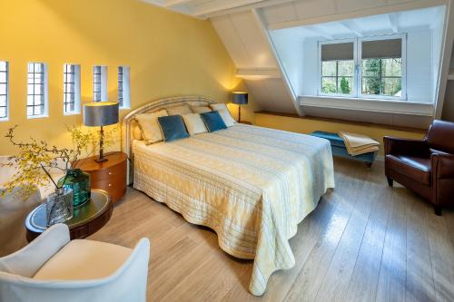een slaapkamer met een groot bed en een stoel bij Londons Cottage in Hilversum