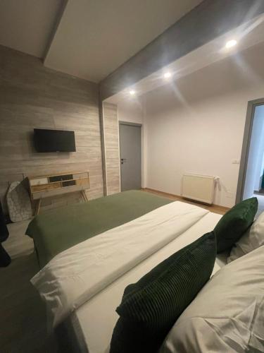 a bedroom with a large bed and a flat screen tv at Marisah Residence #3 in Otopeni