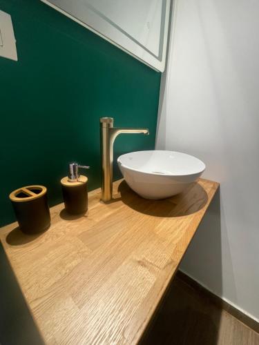 a bathroom with a white sink on a wooden counter at Marisah Residence #3 in Otopeni