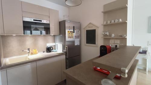 une cuisine avec un évier et un réfrigérateur dans l'établissement Le Magellan Appartement Terrasse 4 personnes plage et centre ville, à Andernos-les-Bains