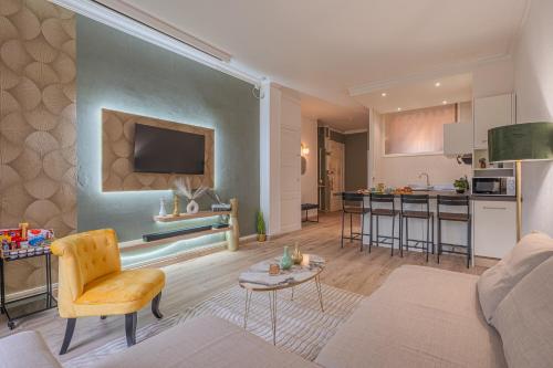 un salon avec un canapé et une cuisine dans l'établissement Luxury Cinephile - Netflix - 2 Balcons - Garage Privé - Minibar, à Grenoble