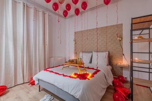 une chambre avec un lit avec des ballons rouges sur le mur dans l'établissement Luxury Cinephile - Netflix - 2 Balcons - Garage Privé - Minibar, à Grenoble
