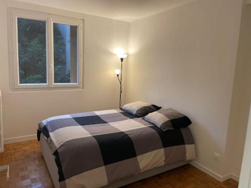 a bedroom with a black and white bed with a window at 5 people/Paris-CDG/France Stadium in Bagnolet