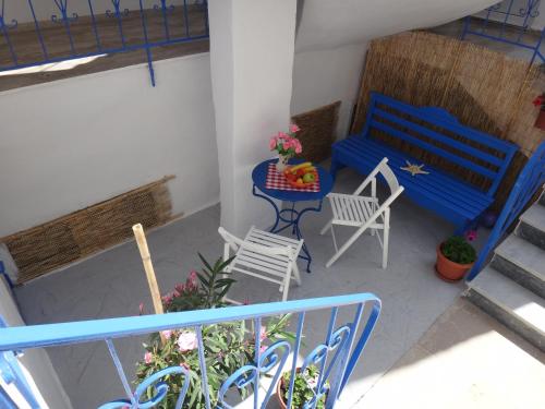 a balcony with a blue bench and a table and chairs at Amfi Apartments in Kardamaina