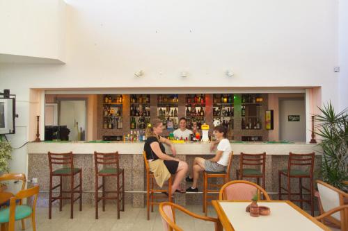 a group of people sitting at a bar at Pola Costa Beach Hotel Apts - Adults Only in Protaras