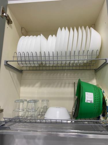a kitchen shelf with plates and a blender and glasses at Isla Home in Naples