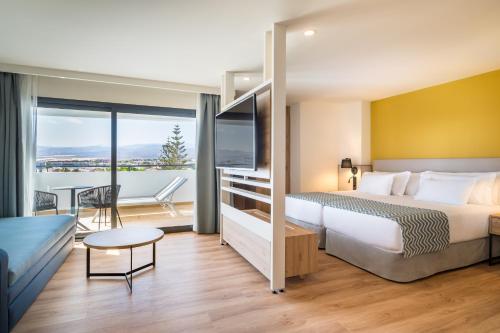 um quarto de hotel com uma cama e uma varanda em Barceló Margaritas em Playa del Inglés
