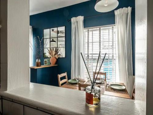a kitchen with blue walls and a counter with a table at Pass the Keys Modern central flat with character features in Exeter