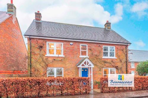 a red brick house with a sign in front of it at TAYLOR DRIVE by BOURNECOAST - A Lovely Countryside Family Home with a Garden and Parking - HB1522 in Bournemouth