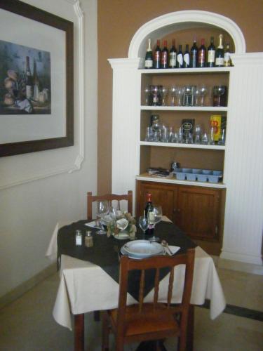 a dining room with a table and chairs and a shelf with bottles at Hotel Mirador in Algeciras