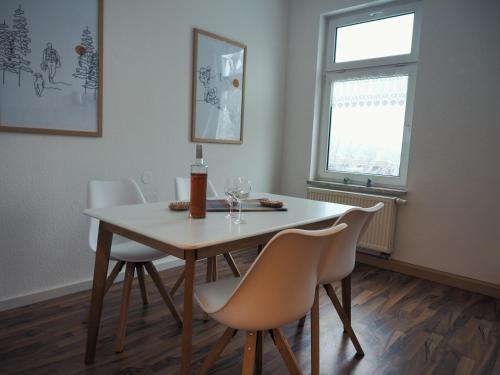 uma sala de jantar com uma mesa e cadeiras e uma janela em NEU - Familienfreundlich - Für bis zu 6 Personen em Oberhof