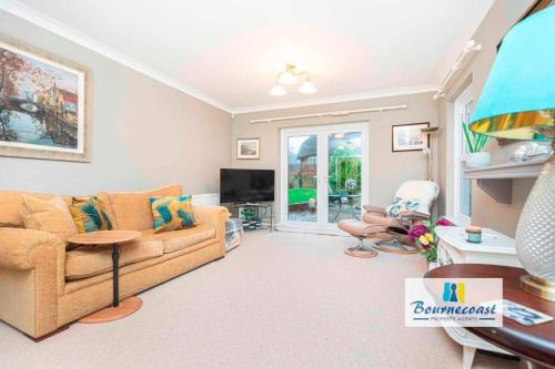 a living room with a couch and a tv at TAYLOR DRIVE by BOURNECOAST - A Lovely Countryside Family Home with a Garden and Parking - HB1522 in Bournemouth