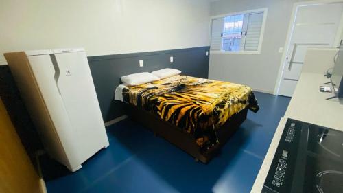 - une chambre avec un lit dans un dortoir doté d'un réfrigérateur dans l'établissement LOFT PRÓXIMO AO FORUM, à Chapecó