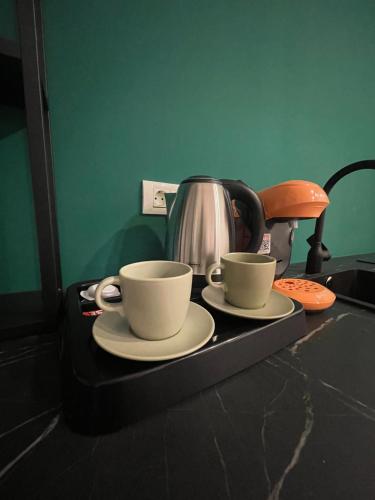 a tray with two coffee cups and a tea kettle at Marisah Residence #3 in Otopeni
