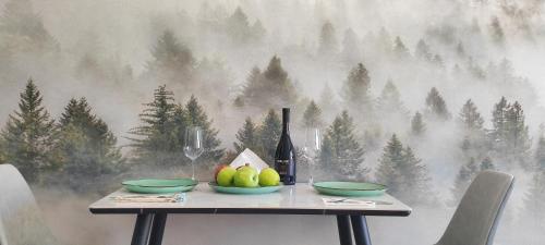 una mesa con dos cuencos de fruta y una botella de vino en VistaRest Gudauri Ski Resort - by VistaRest Escapes & Stays, en Gudauri