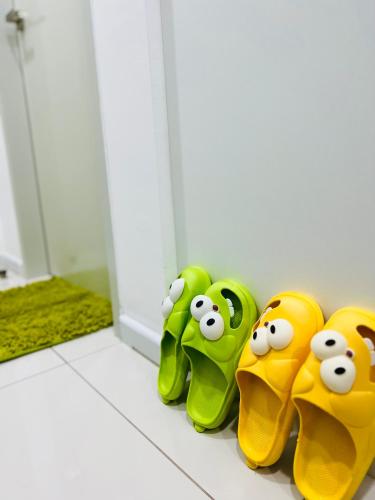 a group of green and yellow childrens shoes on a bathroom floor at C&Y Horizon Suites Homestay Sepang - KLIA Transit - Near XiaMen University in Kampong Melot