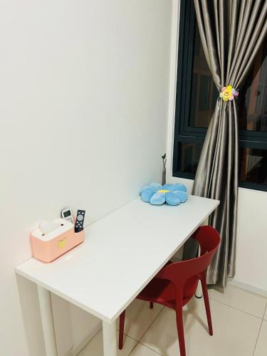 a white table with a red chair next to a window at C&Y Horizon Suites Homestay Sepang - KLIA Transit - Near XiaMen University in Kampong Melot