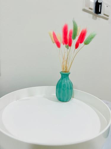 a vase with red flowers sitting on a table at C&Y Horizon Suites Homestay Sepang - KLIA Transit - Near XiaMen University in Kampong Melot